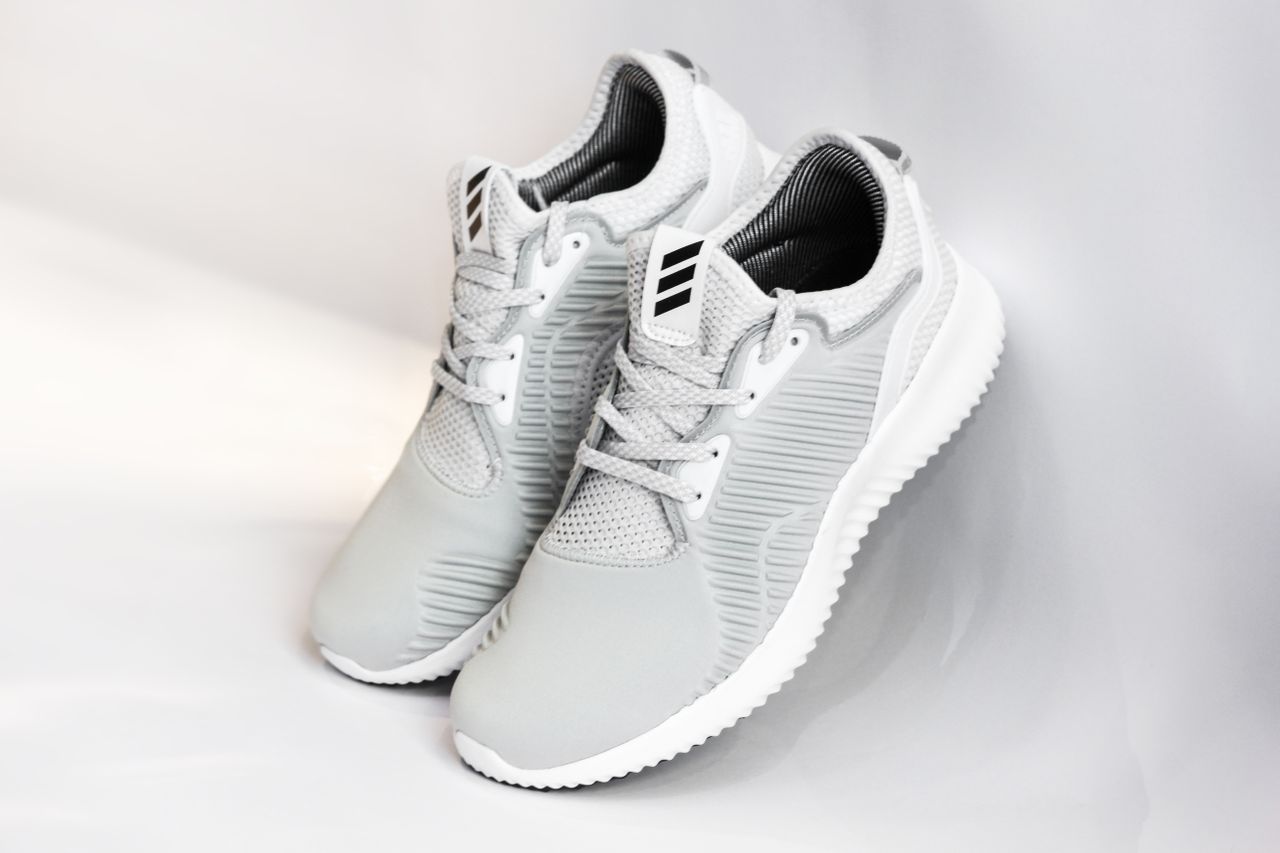 Basket de sport grise style Adidas sur fond clair